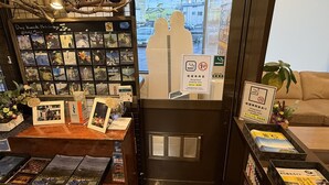 Een hotel receptie met een kaartposten display en een bordje dat een rookruimte aangeeft.