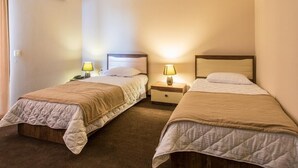A hotel room with two single beds, each with a bedside table and lamp, and a large window on the left. - Check-in TERRACE Hotel (Baku)