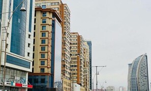 A row of high-rise residential buildings with a modern architectural style, featuring multiple balconies and large windows. - Check-in TERRACE Hotel (Baku)