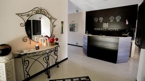 A reception area with a black counter, a large mirror, and a framed artwork on the wall. - Check-in TERRACE Hotel (Baku)