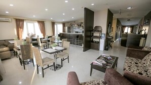 A spacious living area with a dining table, comfortable seating, a kitchen area, and a wine rack. - Check-in TERRACE Hotel (Baku)
