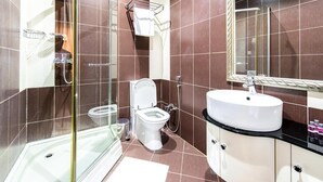 A modern bathroom with a glass shower enclosure, a white toilet, and a vanity with a mirror. - Check-in TERRACE Hotel (Baku)