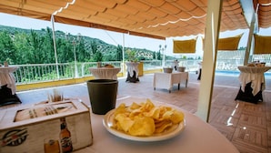 A terrace with tables set up for dining, overlooking a mountainous landscape. - Hotel Avenida (Beas de Segura)