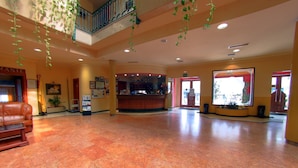 A spacious lobby with a marble floor, a reception desk, and a staircase leading to an upper level. - Hotel Avenida (Beas de Segura)