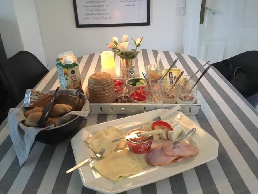 A breakfast buffet with various food items and utensils on a striped table.