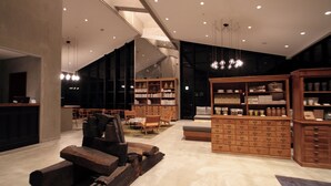 Ein modernes Interieur mit einer zentralen Sitzecke, Holzschränken und einem großen Bücherregal.