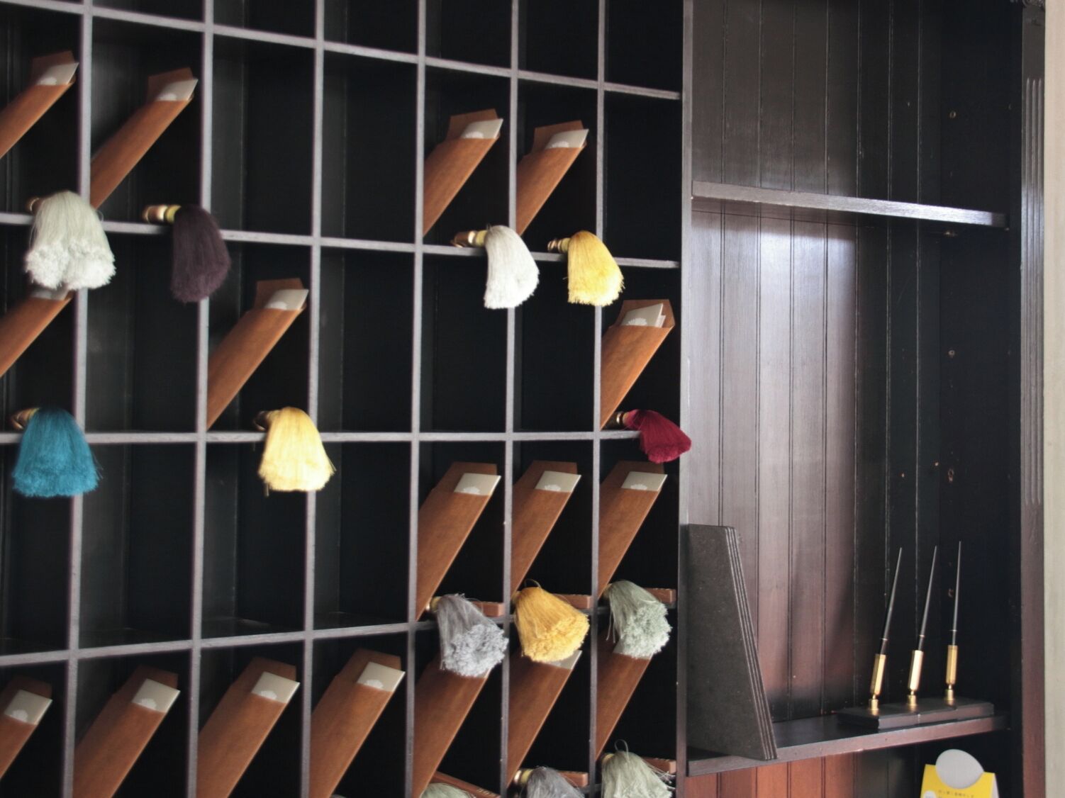 A room with a grid of wooden shelves holding various items.