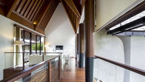 A modern interior with a wooden staircase, glass railings, and a large cylindrical column. - Luxury Villa in Bali near Beach, Bali Villa 2003 (Seminyak)