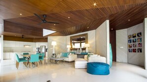 A spacious living area with a modern kitchen, white furniture, and a ceiling fan. - Luxury Villa in Bali near Beach, Bali Villa 2003 (Seminyak)