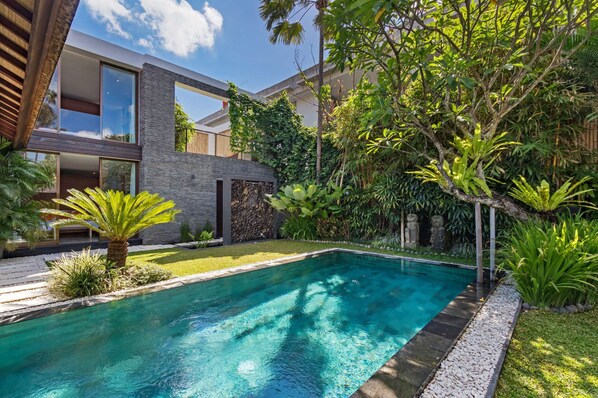 A modern house with a swimming pool surrounded by lush greenery and a clear blue sky. - Beautiful Villa With Private Pool, Bali Villa 2028 (Seminyak)