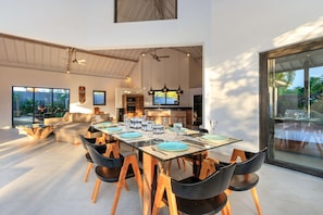 A spacious dining area with a high ceiling and large windows, modern furniture, and a view of the outdoors. - Bali Villa Near the Beach, 2041 (Seminyak)