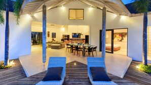 Une villa moderne dotée d’un patio couvert, d’un coin repas et d’une chambre.