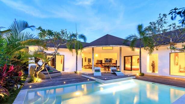 Une villa moderne dotée d’une piscine, d’un espace salon extérieur et d’un patio couvert.