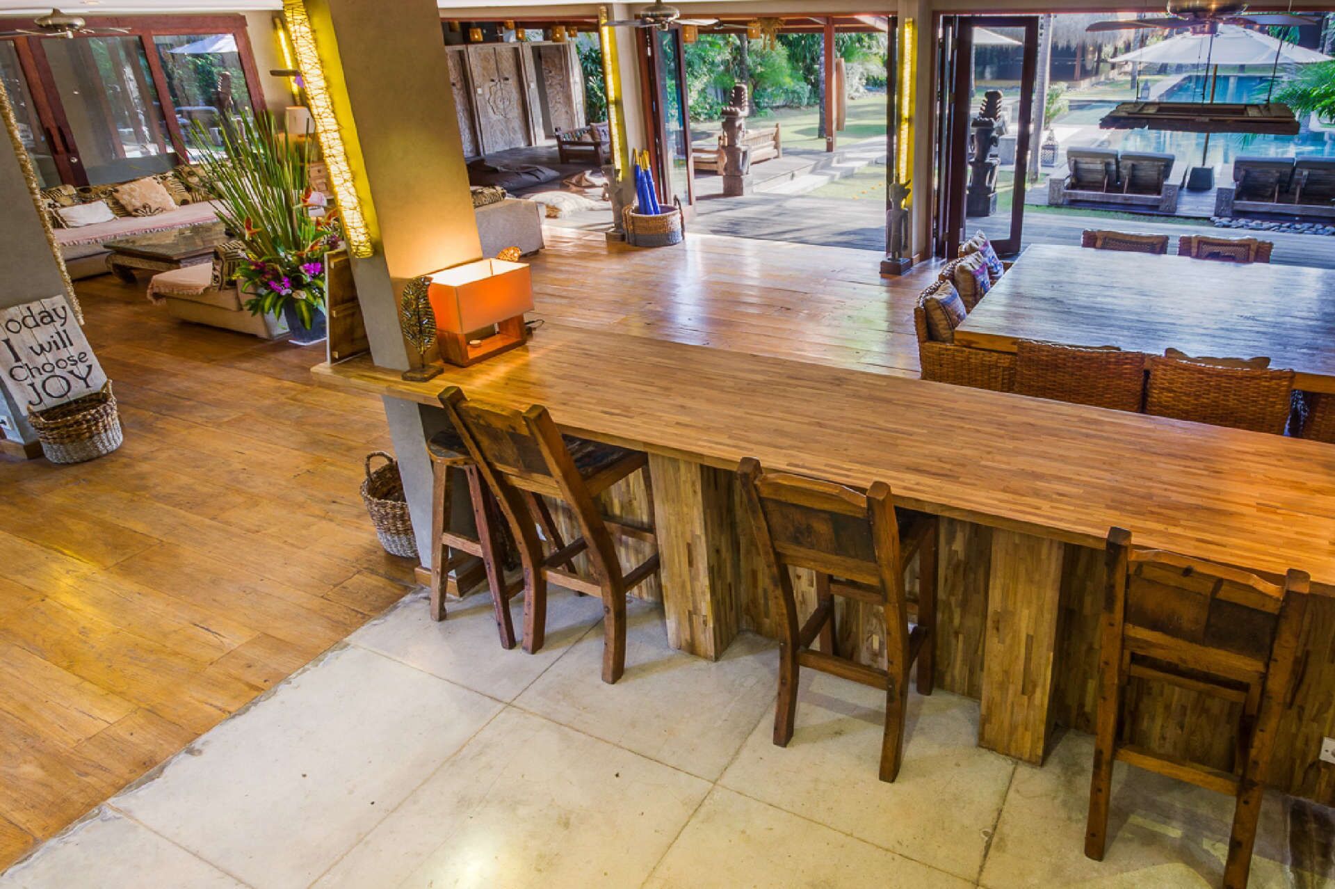 Un amplio bar con sillas de madera y una barra larga, rodeado de diferentes opciones de asientos y elementos decorativos.