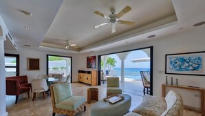 A spacious living room with a large sofa, armchairs, and a dining area. - Dream Villa Shore Point 553 (Lowlands)