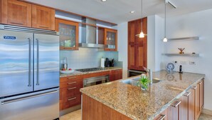 A modern kitchen with wooden cabinets, a stainless steel Viking refrigerator, granite countertops, and a built-in oven. - Dream Villa Shore Point 553 (Lowlands)