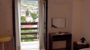 A hotel room with a balcony, a bed, a small desk, and a nightstand. - Apartments Nadia (Bol)