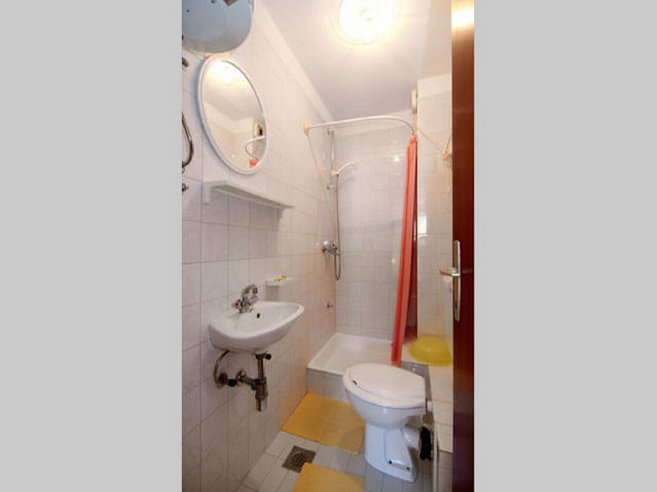 Un baño con lavamanos, inodoro y ducha.