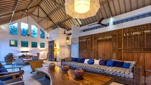 A spacious living area with a long wooden table, wicker sofa with blue cushions, and a large wooden cabinet with intricate carvings. - Bali Villa Near the Beach, 2056 (Seminyak)