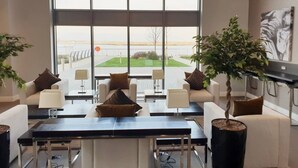 A modern hotel lobby with a large window, seating area, and a central table. - Pier Apartment 3 (Gillingham)