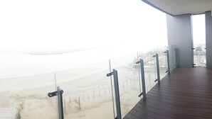 A balcony with a view of a beach and cityscape. - Pier Apartment 3 (Gillingham)