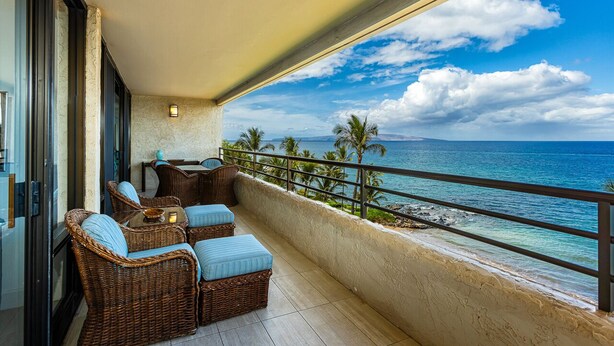 A balcony with wicker furniture, a view of the ocean, and a clear sky. - Beachfront Wailea condo w/ ocean views and lanai (Wailea)