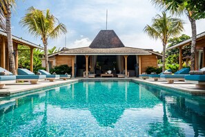 A pool area with lounge chairs and a building with a pyramid roof. - Luxury 4 Bedroom Villa With Private Pool, Bali Villa 2006 (Kerobokan)