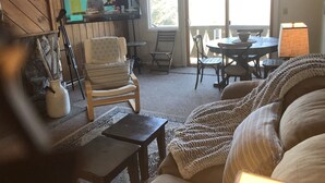 A cozy living room with a wooden wall, a comfortable chair, a small table, and a sofa. - Slopeside  at Hunter Mountain (Hunter)