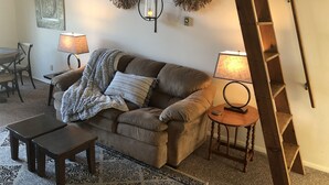 A cozy living room with a brown sofa, two small tables, and a ladder against the wall. - Slopeside  at Hunter Mountain (Hunter)