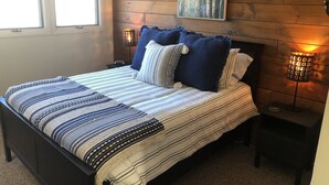 A bedroom with a large bed, two bedside lamps, a wooden headboard, and a window. - Slopeside  at Hunter Mountain (Hunter)
