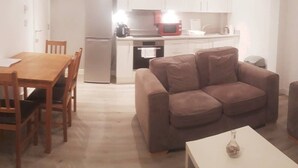 A compact living space with a dining area, kitchenette, and a sofa. - Riverside 2 (Maidstone)