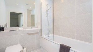A modern bathroom with a glass-enclosed shower, a white sink, and a toilet. - Riverside 2 (Maidstone)