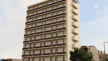 A multi-story hotel building with a prominent 'AB HOTEL' sign on the facade.
