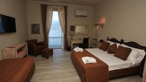 Una habitación de hotel con cama, escritorio, silla, sofá y televisor.