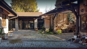 Ein Innenhof mit Kopfsteinpflaster, einer überdachten Sitzgelegenheit und Pflanzkübeln.