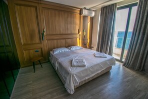 Appartement Deluxe, cuisine, vue sur la plage | Couette en duvet, lit avec matelas à plateau-coussin, coffre-fort