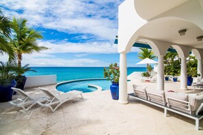 A poolside area with lounge chairs and a view of the ocean. - Dream Villa Shore Point 552 (Lowlands)