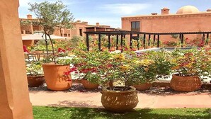 A courtyard with potted plants and a pergola. - Splendid Apartment in the Jardins de l'Atlas 4620 (Marrakech)