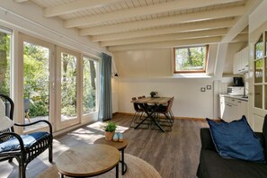 A spacious living area with a dining table, a sofa, and a kitchen area.