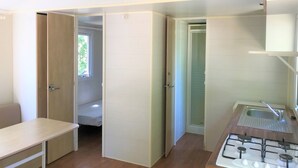 A compact kitchen with a gas stove, a sink, and a window. - Les Bastides de Chanteraine (Aiguines)