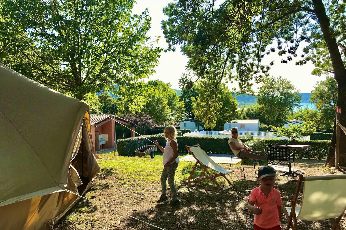 A tented area with a small building, a table, and a chair.