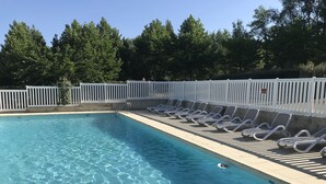 A swimming pool with clear water, surrounded by a white fence and trees in the background. - Les Bastides de Chanteraine (Aiguines)