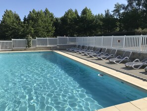 季节性开放的室外游泳池，池畔遮阳伞，日光浴躺椅