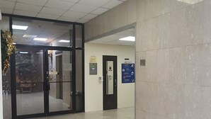 A spacious lobby with a tiled floor, glass doors leading to another area, and a wall-mounted sign. -  HEART OF SAN JUAN (Santurce)