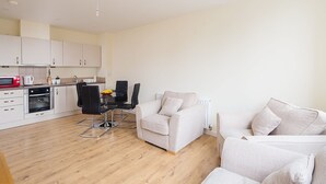 A modern apartment with a kitchen, dining area, and living room. - Golden Heights 9 (Maidstone)