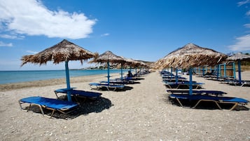 En la playa, arena blanca, camas de playa, sillas reclinables de playa