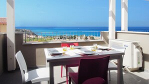 A balcony with a table set for two, overlooking a coastal view. - Affittimoderni Castelsardo Incanto - Csso15 (Castelsardo)