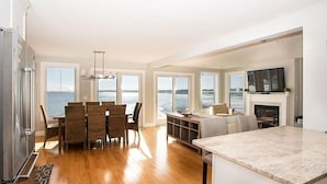 A spacious kitchen with a large island, dining area with chairs, and a view of the sea through large windows. - Epic Ocean Vista, a Few Steps to the Beach, an Unforgettable Vacation ! (York)