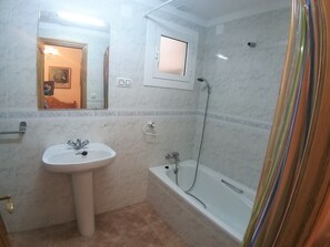 A bathroom with a sink, mirror, and bathtub. - Colera House Costa Brava (Colera)
