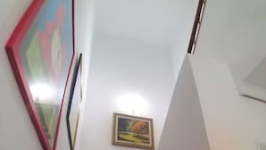 A staircase with a wooden handrail, a framed painting on the wall, and a small picture frame. - Colera House Costa Brava (Colera)